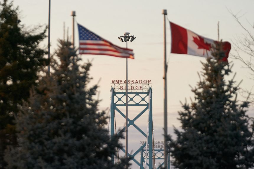 Canadian and American flags fly on the Canadian side of the Ambassador Bridge in Windsor, Ontario, on March 8.