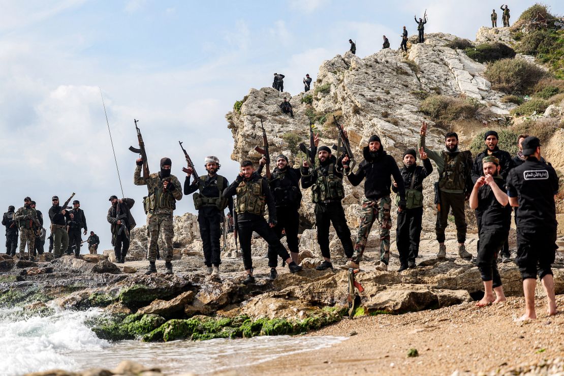 Members of security forces loyal to the interim Syrian government pose for a photo by the coast of the Mediterranean Sea in Latakia on Sunday.