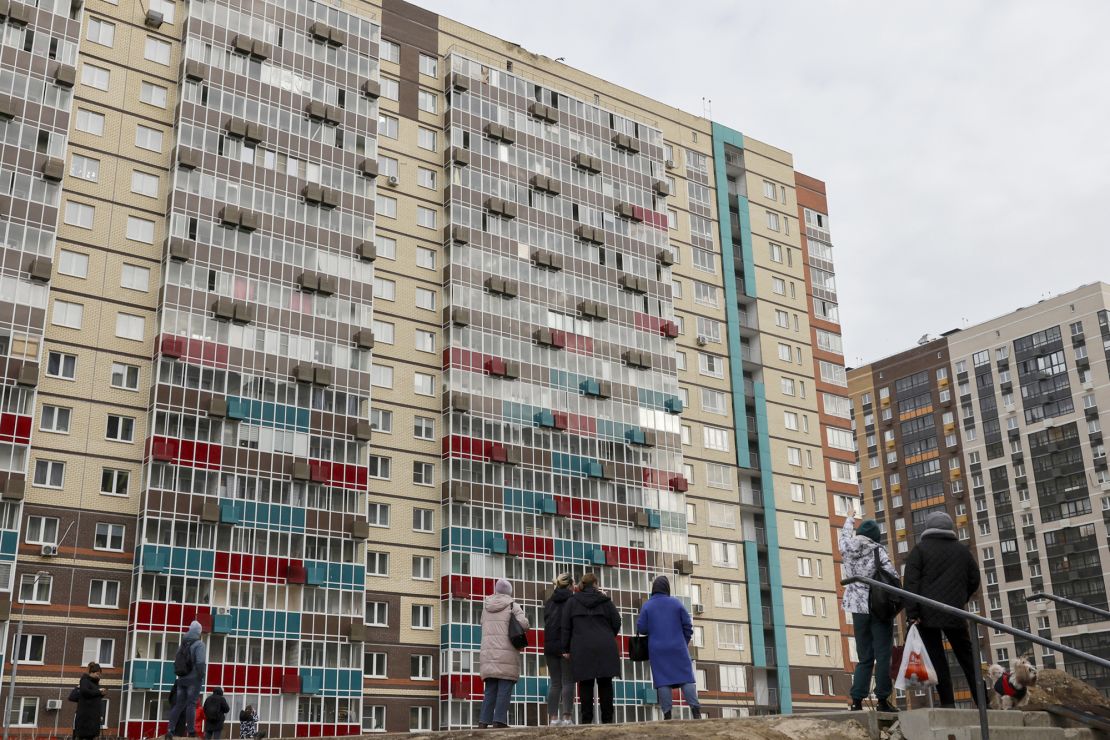 People gather in the yard in front of an apartment building with its roof damaged in a recent drone attack in the village of Misaylovo in the Moscow region, Russia, on Monday.