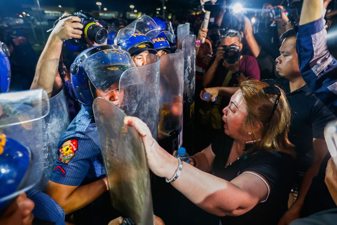 A supporter of Duterte confronts riot police officers outside the Villamor Airbase.