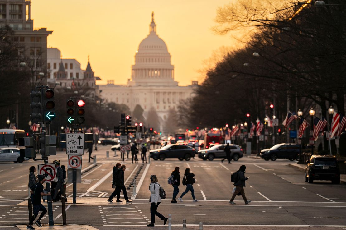 Commuters cross Pennsylvania Avenue near the US Capitol in Washington, DC, on March 12, 2025.