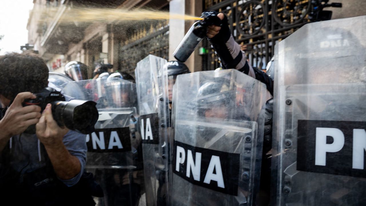 BUENOS AIRES, ARGENTINA - MARCH 12: Riot police spray gas to demonstrators during a protest against the government of Javier Milei on March 12, 2025 in Buenos Aires, Argentina. Pensioners and  of labor unions gather to protest against the government on the pension system and the cutback of benefits and rights. Fans of different teams ed the protest to  the pensioners' claims. (Photo by Tomas Cuesta/Getty Images)