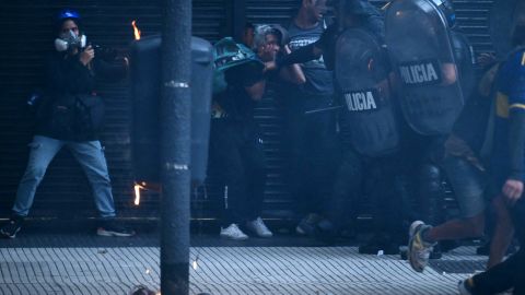 Riot police officers arrest a woman during a protest of pensioners ed by football fans against the government of President Javier Milei in Buenos Aires on March 12, 2025. (Photo by Luis ROBAYO / AFP) (Photo by LUIS ROBAYO/AFP via Getty Images)          
