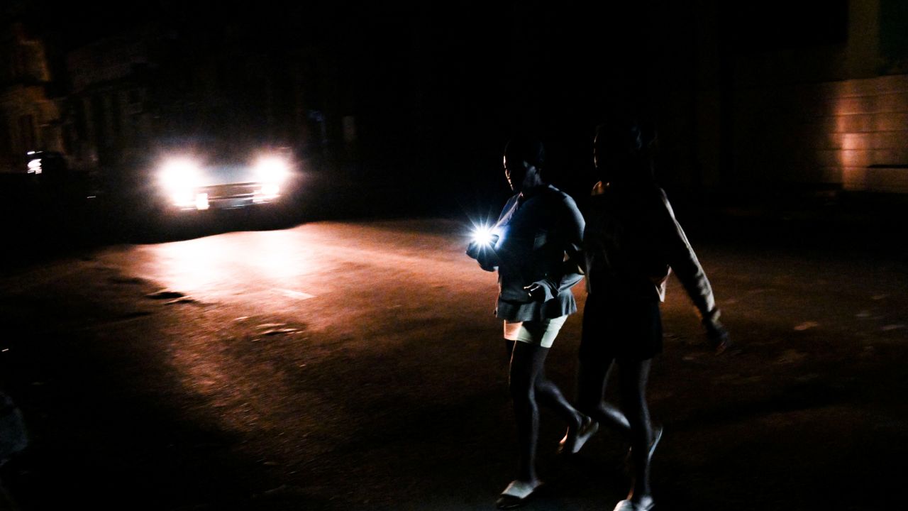 TOPSHOT - Cubans cross a street during a general blackout in Havana on March 14, 2025. Cuba suffered another general blackout on March 14, 2025, caused by a failure in its national electricity system, the Ministry of Energy and Mines reported. (Photo by YAMIL LAGE / AFP) (Photo by YAMIL LAGE/AFP via Getty Images)          