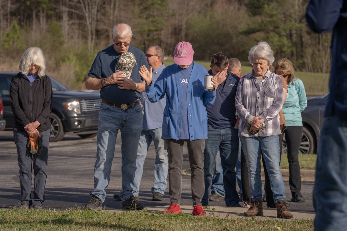 Calera Baptist church members pray before beginning clean up after the church was hit by a tornado on Sunday in Calera, Alabama.