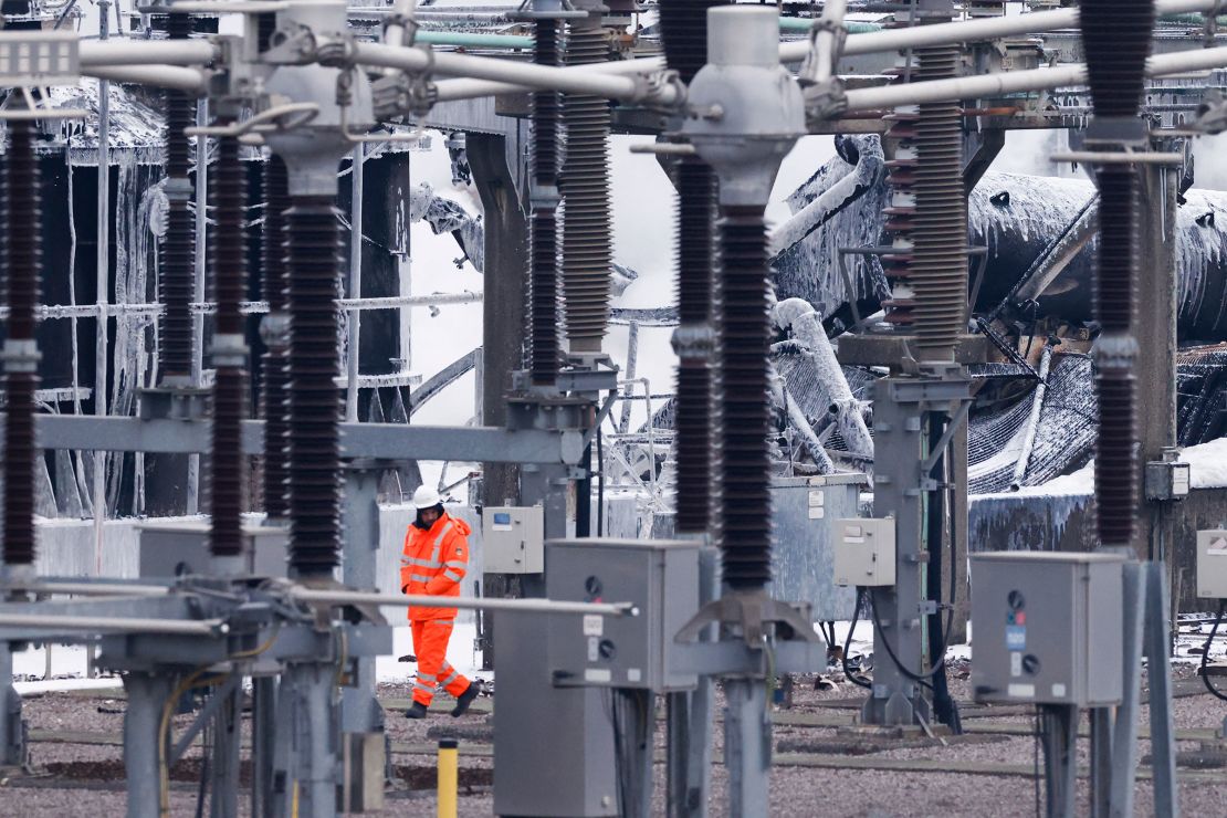 A staff member walks past the substation supplying power to Heathrow Airport where a fire broke out in Hayes, west London, on March 21, 2025.