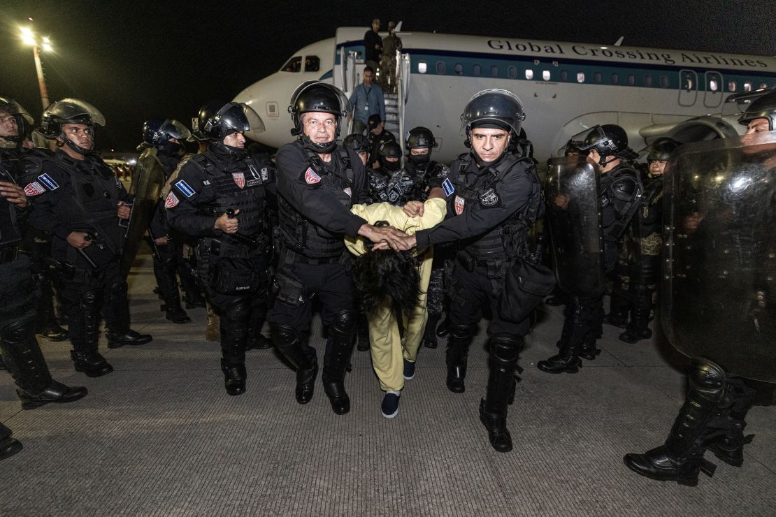 En esta foto facilitada por el gobierno salvadoreño, los guardias escoltan a un nuevo recluso supuestamente vinculado a organizaciones criminales en Cecot el 16 de marzo de 2025 en Tecoluca, El Salvador.
