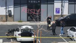 Investigators look over the scene at a Tesla collision center after an individual shot and set fire to several Tesla vehicles on Tuesday in Las Vegas.