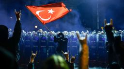 Un manifestante ondea la bandera nacional de Turquía ante la policía antidisturbios turca, mientras los manifestantes protestan frente al ayuntamiento de Estambul para apoyar al alcalde de Estambul, Ekrem Imamoglu, en Estambul, este sábado.