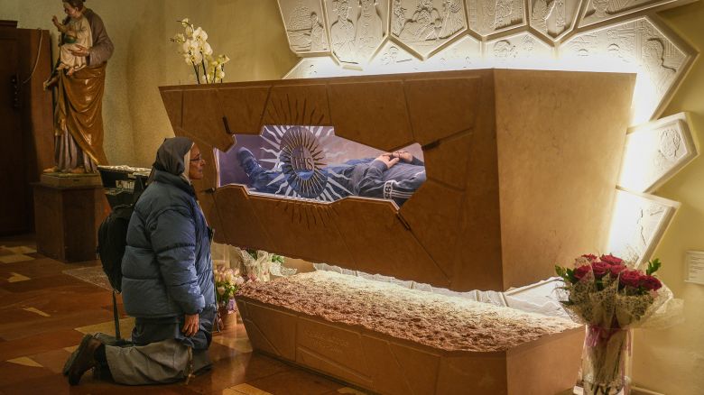 ASSISI, ITALY - MARCH 18: (EDITORS NOTE: This image depicts death.) A nun prays at the tomb of Blessed Carlo Acutis in the Church of Santa Maria Maggiore on March 18, 2025 in Assisi, Italy. Assisi is the resting place of Carlo Acutis, a London-born Italian teenager who died from leukemia in 2006 and was later beatified by Pope Francis in 2020. Acutis, who has been referred to as "God's Influencer," will become the first millennial saint when he is canonised in a ceremony next month during the Church's Jubilee of Teenagers.  It was Carlos Acutis's final wish to be buried in Assisi. On 6th April 2019, his body was brought to the Sanctuary of the Spoliation and will be his final resting, attracting pilgrims from across the world to visit his tomb and that of St. Francis of Assisi in the nearby Basilica of St. Francis of Assisi. (Photo by Christopher Furlong/Getty Images)