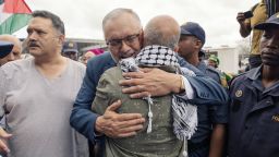 Former South African Ambassador to the United States Ebrahim Rasool (c), greets relatives and supporters upon his arrival at the Cape Town International airport, in Cape Town, on March 23, 2025. Ties between Washington and Pretoria have slumped since Trump cut financial aid to South Africa over its land policy, genocide case against US ally Israel and other foreign policy clashes. US Secretary of State Marco Rubio said last week Rasool was expelled after he described Trump's Make America Great Again movement as a supremacist reaction to diversity in the US.