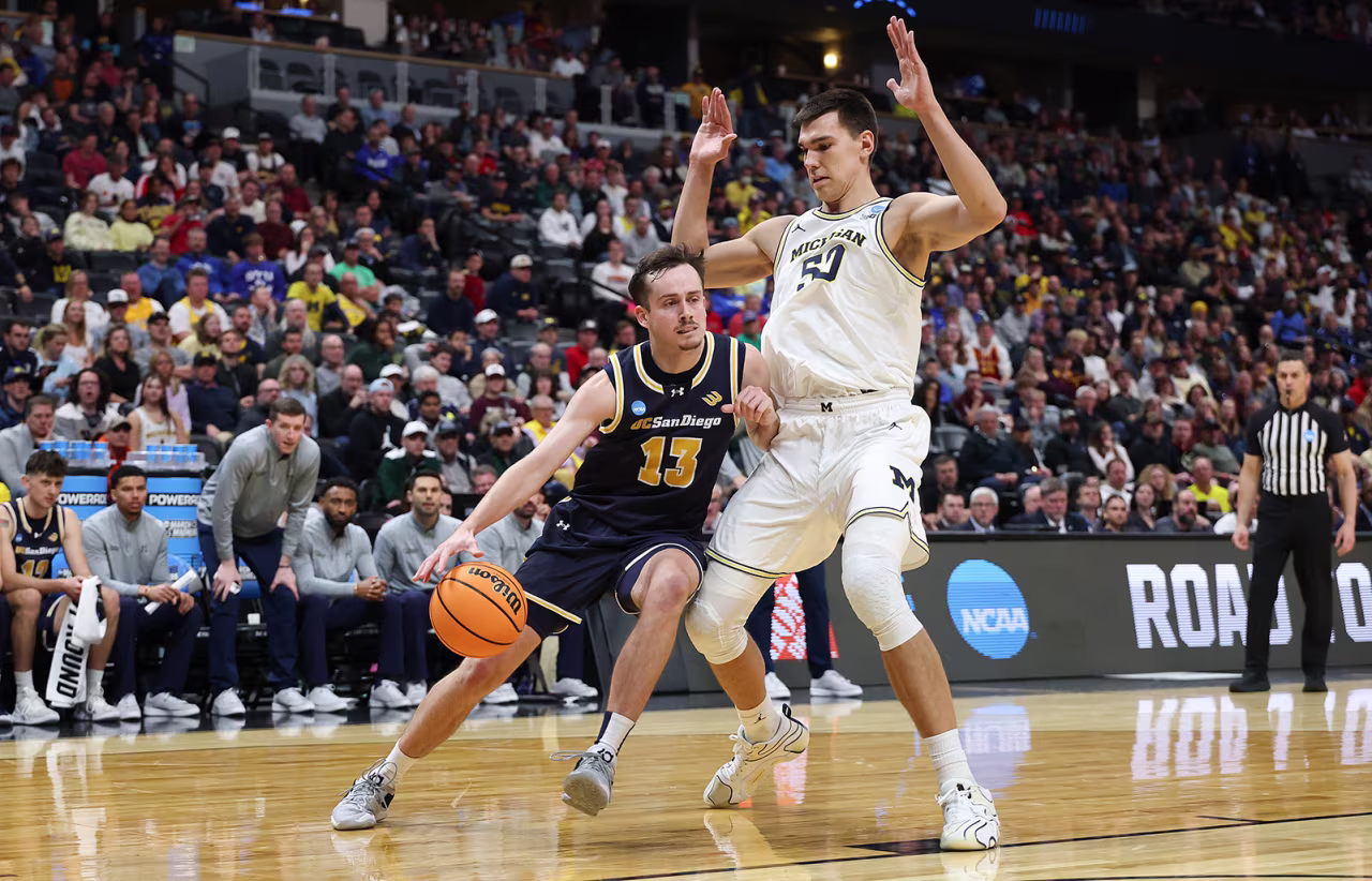 Tyler McGhie #13 of the UC San Diego Tritons drives against Vladislav Goldin #50 of the Michigan Wolverines during the NCAA Men's Basketball Tournament at Ball Arena in Denver, Colorado on Thursday.
