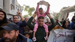 Arabic signs reading (left), 'The children of Palestine: We want to live,' and (right), 'Enough killing and destruction,' at a protest in Beit Lahia, in the northern Gaza Strip, on Tuesday.