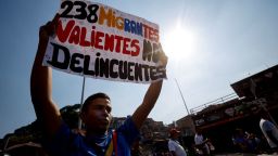 Una mujer sostiene un cartel que dice "238 valientes migrantes, no deincuentes" durante una marcha en apoyo a los migrantes venezolanos deportados de Estados Unidos a El Salvador en Caracas el 25 de marzo de 2025.