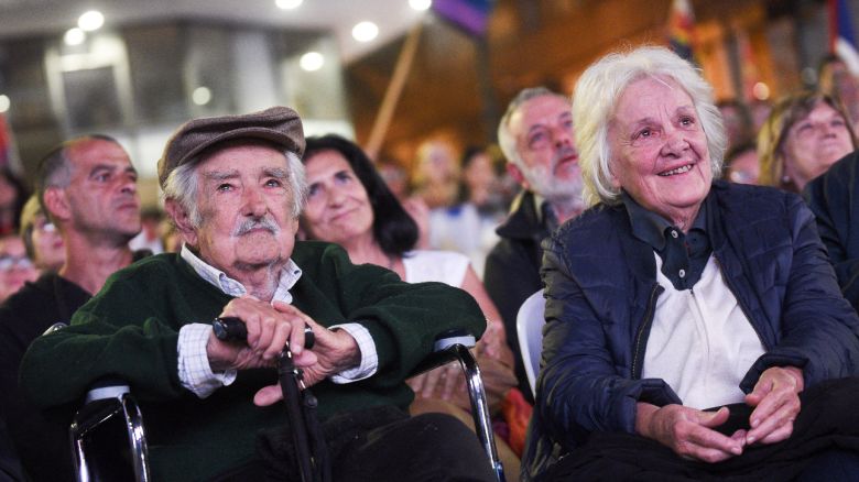 Former Uruguayan President Jose Mujica (L) reacts next to his wife, former Vice President Lucía Topolansky, after receiving a tribute during the 54th anniversary of the Frente Amplio political coalition in Montevideo on March 26, 2025. (Photo by Sofia TORRES / AFP) (Photo by SOFIA TORRES/AFP via Getty Images)          