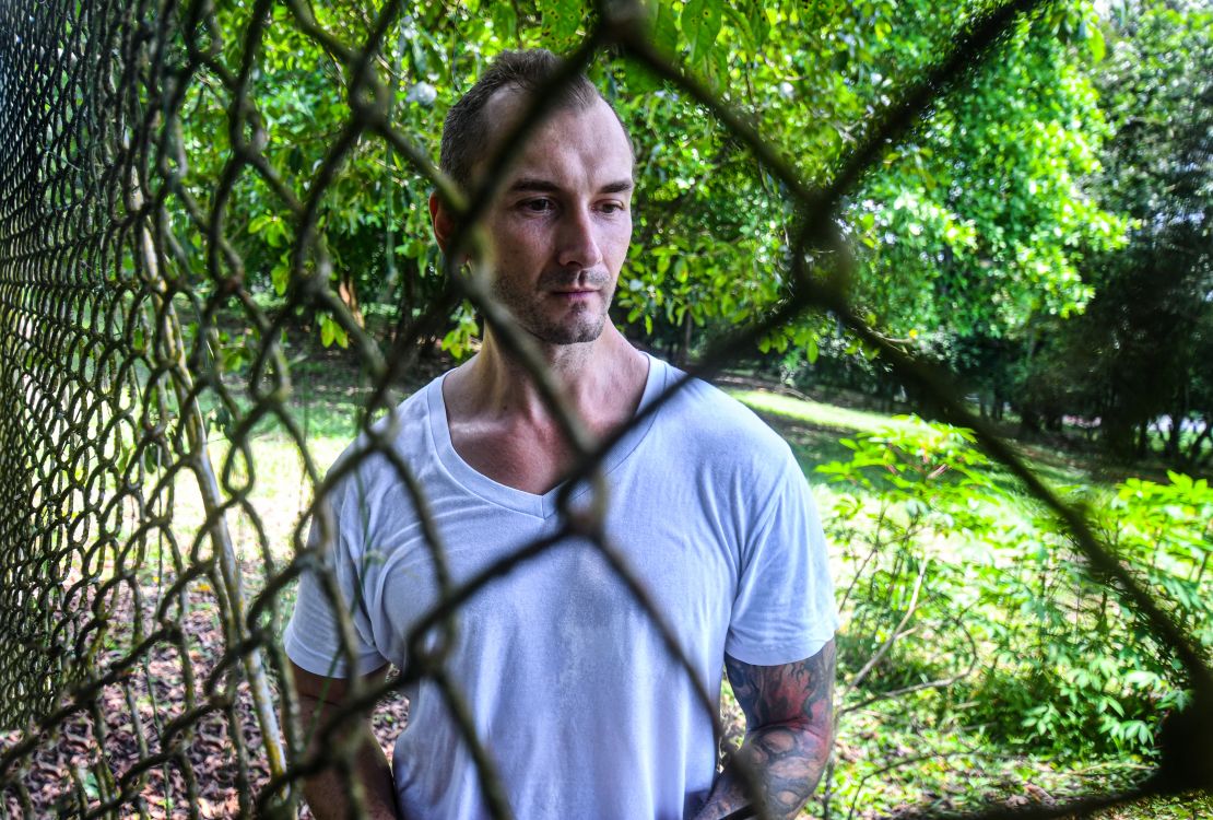 El ruso German Smirnov permanece junto a una valla en el Centro de Atención Temporal para Migrantes (Catem) en Puntarenas, Costa Rica, el 23 de marzo de 2025.