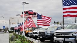 Banderas estadounidenses ondean frente a un concesionario de automóviles en Alhambra, California, el 27 de marzo de 2025, después de que el presidente Donald Trump anunciara aranceles a la importación de vehículos y repuestos.