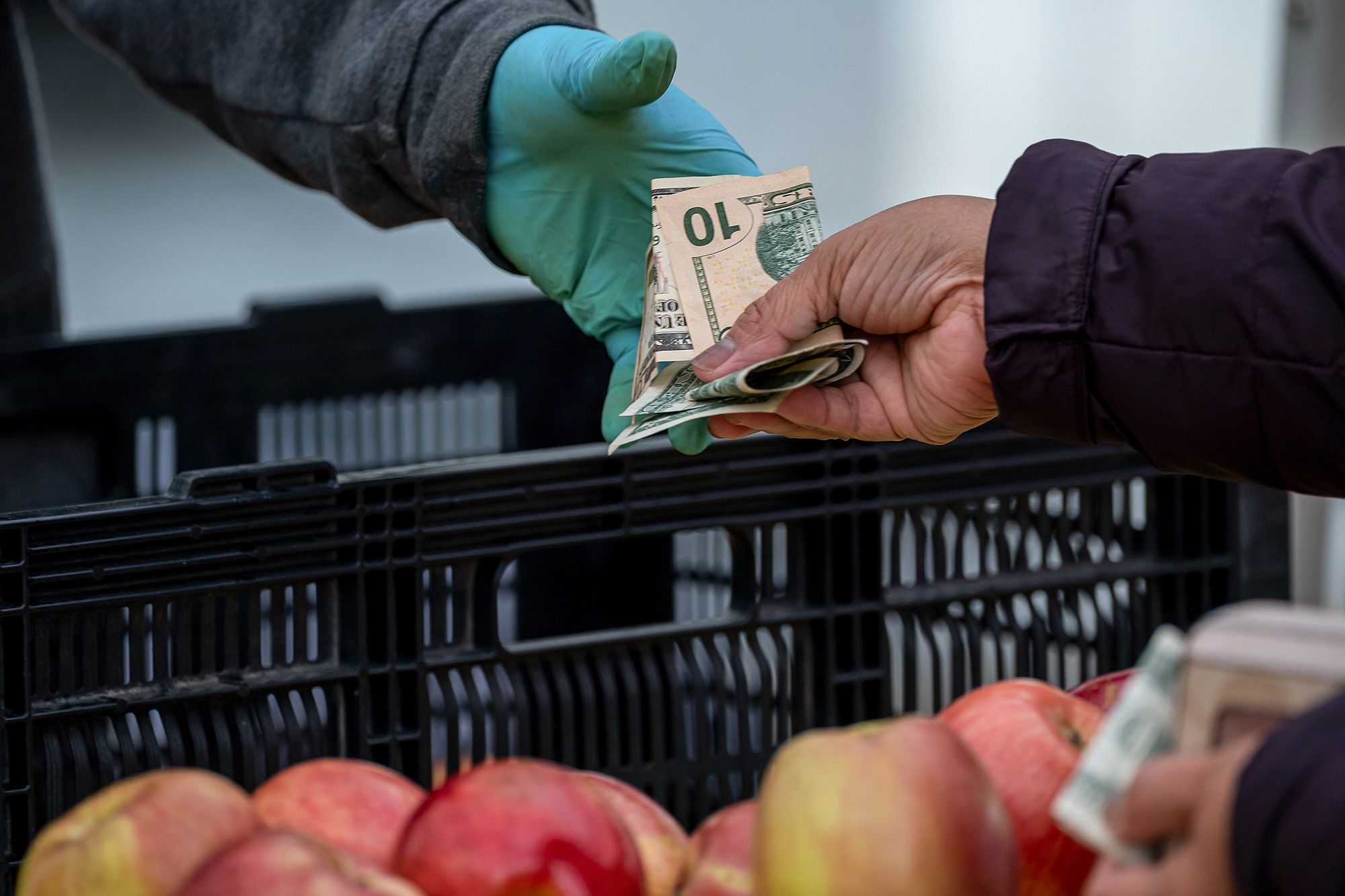 A shopper pays for produce at a farmer