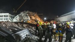 Rescue teams arrive with a stretcher to evacuate an injured man at a construction site where a building collapsed in Bangkok on March 28, 2025, following an earthquake. A powerful earthquake killed more than 20 people across Myanmar and Thailand on March 28, toppling buildings and bridges and trapping over 80 workers in an under-construction skyscraper in Bangkok. (Photo by Chanakarn Laosarakham / AFP) (Photo by CHANAKARN LAOSARAKHAM/AFP via Getty Images)          