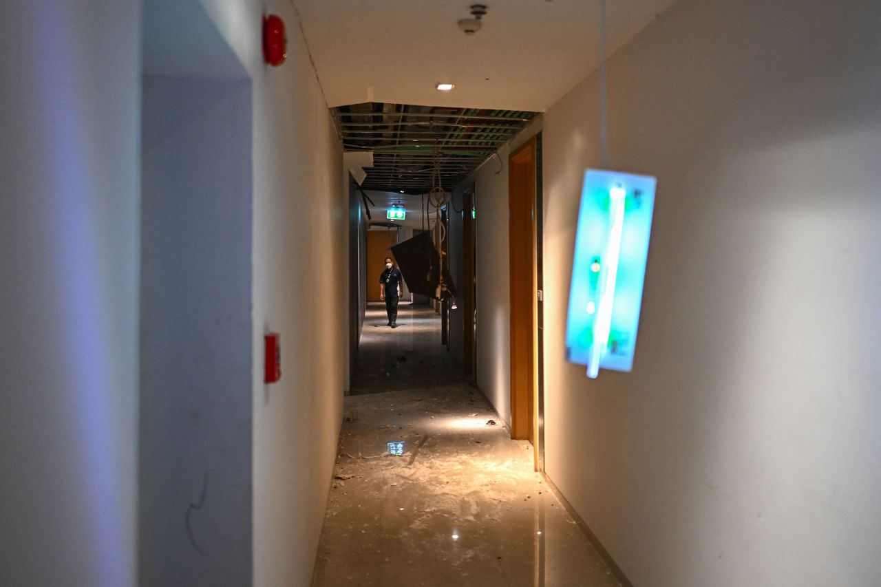 A private security guard walks through a damaged corridor inside a high-rise condominium in Bangkok, Thailand, on Saturday.