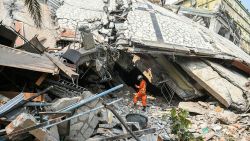 TOPSHOT - A rescue worker stands on rubble as teams attempt to free trapped residents at the destroyed Sky Villa Condominium development in Mandalay on March 29, 2025, a day after an earthquake struck central Myanmar. More than 90 people could be trapped inside the crushed remains of an apartment block in Mandalay in central Myanmar destroyed by a devastating earthquake, a Red Cross official told AFP on March 29 as rescuers worked to free the victims. (Photo by Sai Aung MAIN / AFP) (Photo by SAI AUNG MAIN/AFP via Getty Images)
