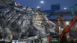 Los equipos de rescate observan cómo la maquinaria pesada retira los escombros en el lugar del derrumbe de un edificio en construcción en Bangkok el 30 de marzo de 2025, dos días después de que un terremoto azotara el centro de Myanmar y Tailandia.