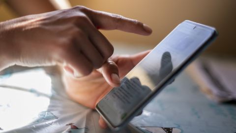 A woman who calls herself Rosario, scrolls WhatsApp messages on her mobile phone at her home in Washington, DC, on March 21, 2025. Fearing a US immigration raid will separate her from her children, an undocumented Honduran immigrant hunkers down in her Washington home, anxiously scouring a WhatsApp group for real-time updates on nearby sweeps. Her only lifeline is a community group on the messaging app that provides news about immigration raids in Washington neighborhoods -- often mixed with unverified or false information. (Photo by STRINGER / AFP) (Photo by STRINGER/AFP via Getty Images)          
