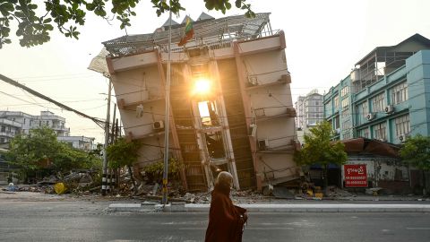 A Buddhist monk walks past a collapsed building in Mandalay on April 1, a few days after the deadly Myanmar earthquake.