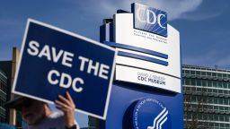 A man holds up a sign outside the main campus of the Centers For Disease Control and Prevention (CDC) on April 1, 2025 in Atlanta, Georgia.