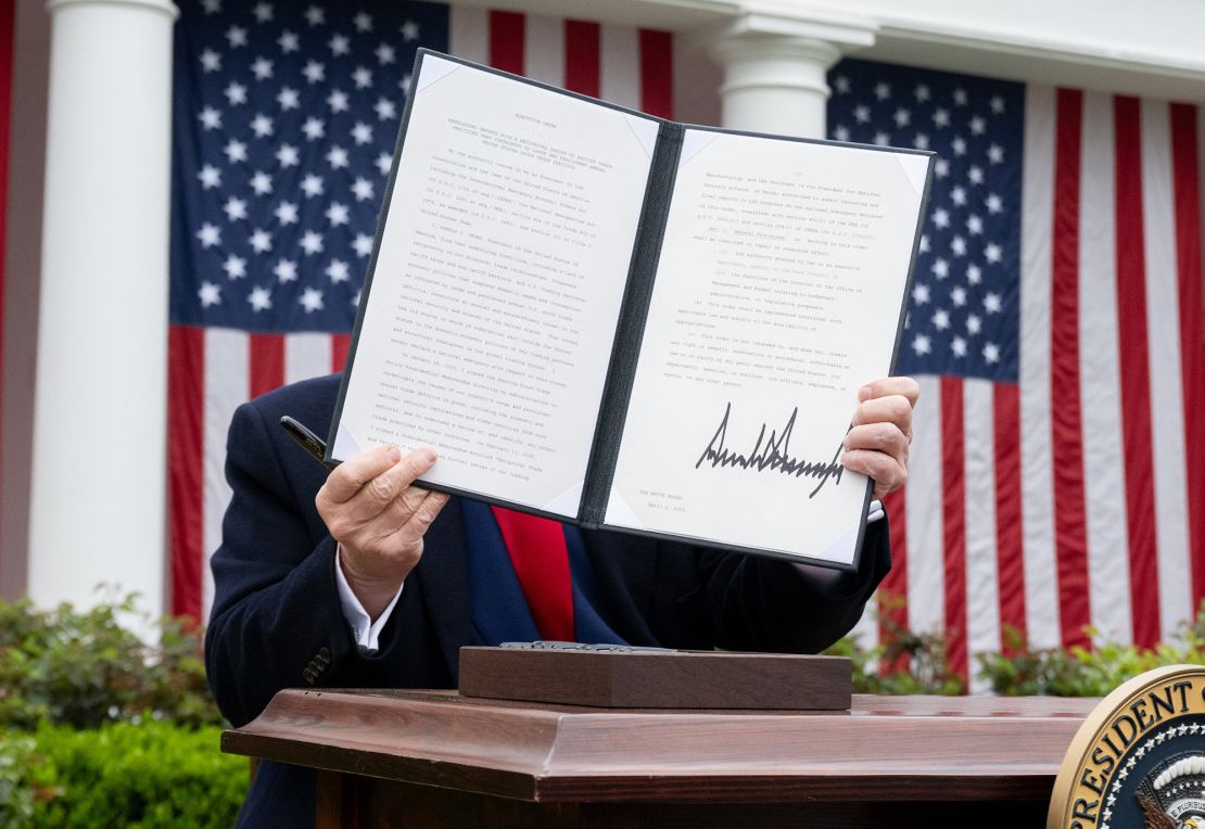 President Donald Trump holds a signed executive order after delivering remarks on