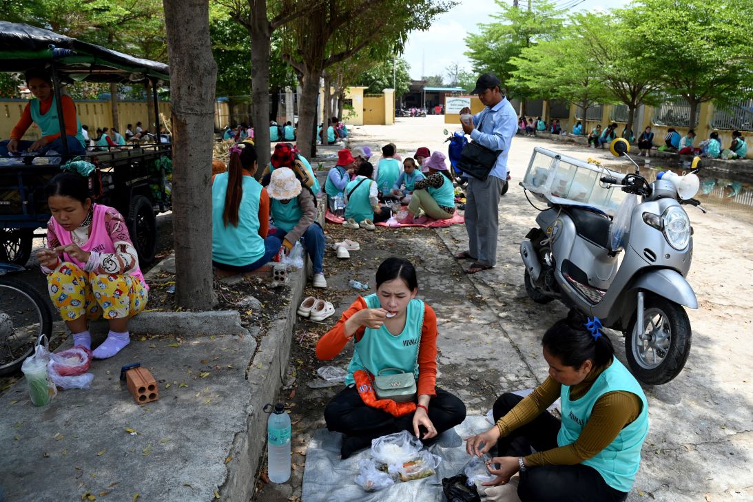 Garment workers have lunch outside their factory in Phnom Penh on April 3, 2025.