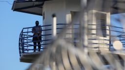 Un funcionario de prisiones vigila la torre de vigilancia del centro penitenciario de máxima seguridad CECOT el 4 de abril de 2025 en Tecoluca, San Vicente, El Salvador.