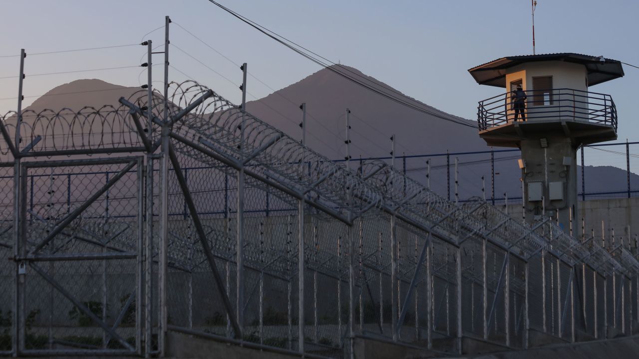SAN VICENTE, EL SALVADOR - APRIL 4: A prison officer stands guard in the watchtower with the San Vicente volcano in the background at maximum security penitentiary CECOT (Center for the Compulsory Housing of Terrorism) on April 4, 2025 in Tecoluca, San Vicente, El Salvador. Amid internal legal dispute, Trump's administration continues with its controversial and fast-paced deportation policy to El Salvador, as part of a partnership with President Bukele. The US Government acknowledged mistakenly deporting a Maryland resident from El Salvador with protected status and is arguing against returning him to the US. (Photo by Alex Peña/Getty Images)