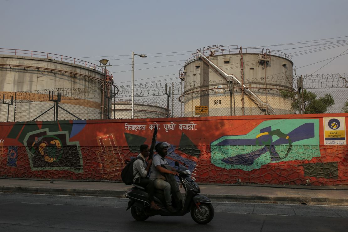 A motorist rides past an oil refinery operated in Mumbai, India, in April.