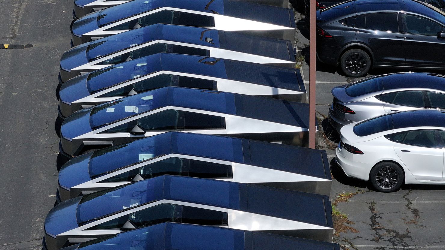 Cybertrucks are parked in a lot outside a Tesla showroom. Tesla reported the two largest drops in sales in its history in the last two quarters.