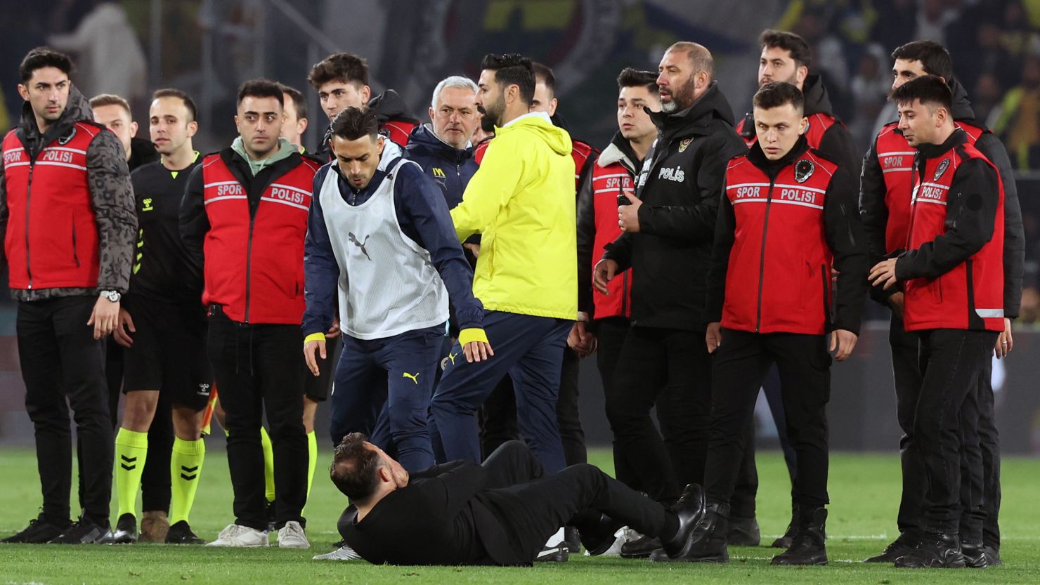 Galatasaray manager Okan Buruk falls to the ground after getting his nose pinched by Fenerbahçe manager José Mourinho on Wednesday in Istanbul, Turkey.