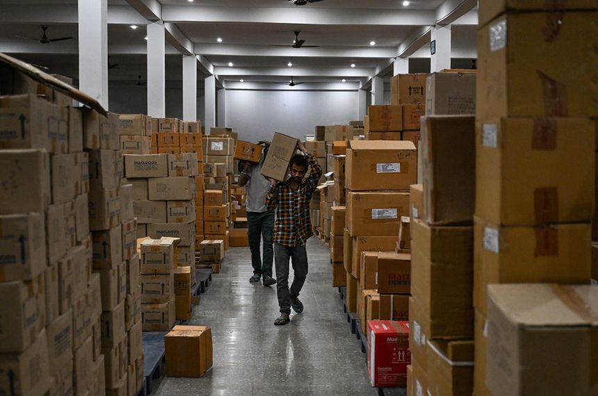 A worker sorts medicine boxes in a warehouse in India.