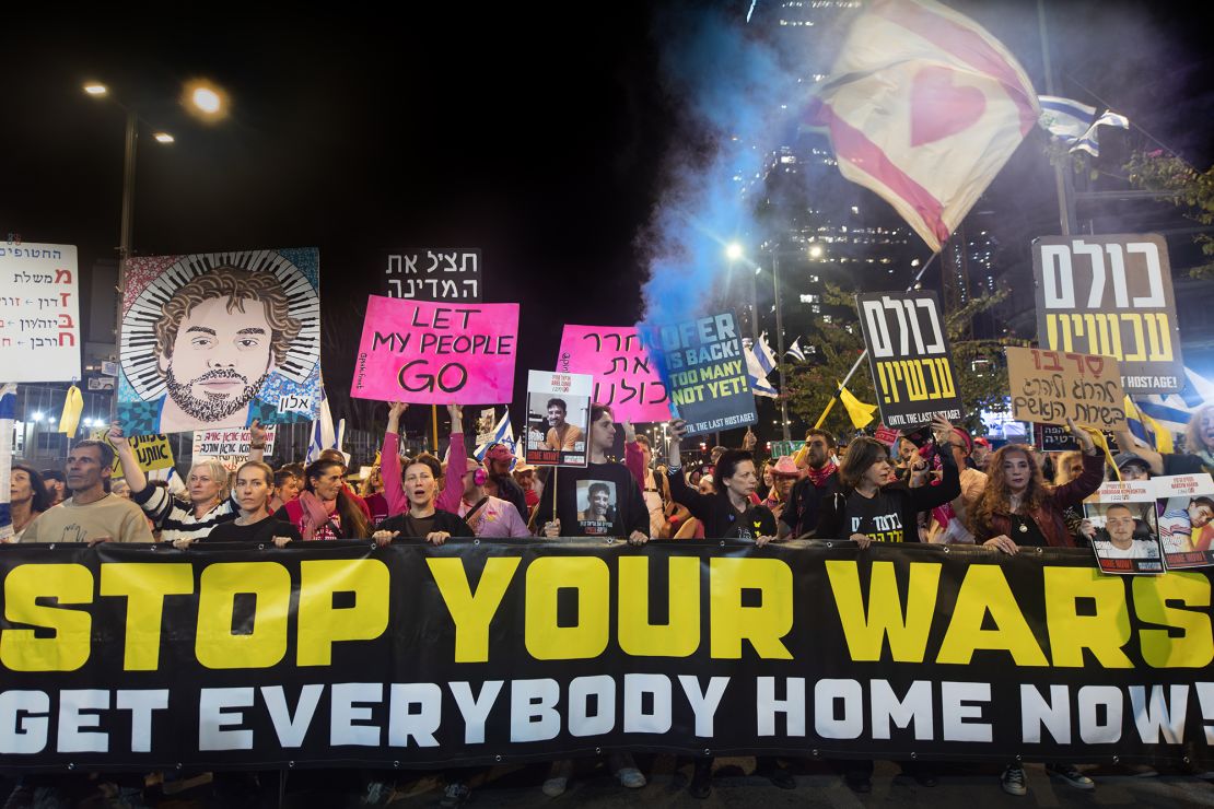 Protesters and families of the hostages hold a banner and placards during a rally, in Tel Aviv, Israel on April 6.
