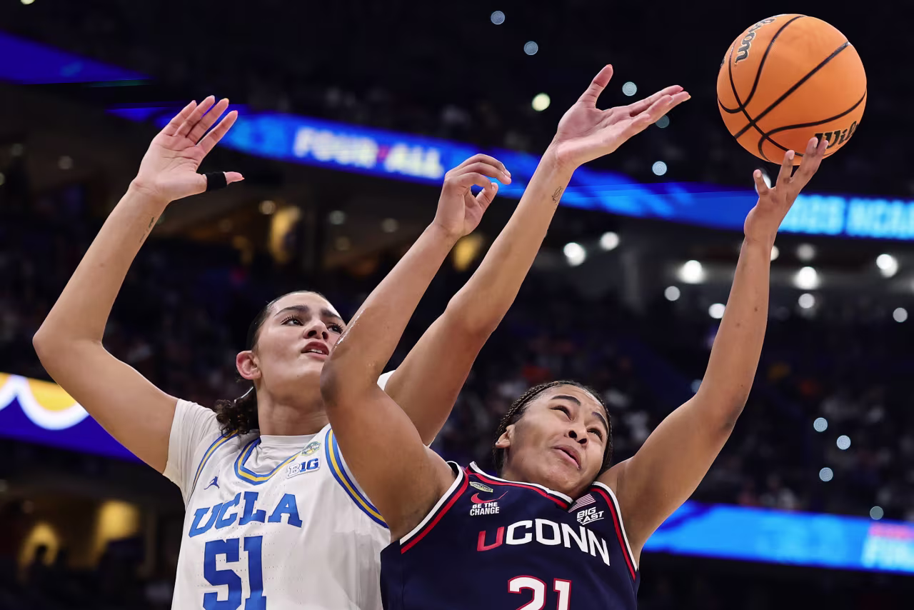 UCLA center Lauren Betts and UConn forward Sarah Strong battle for the ball.