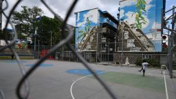 Niños juegan frente a un edificio intervenido con el mural artístico en el barrio de Zacamil, Mejicanos, El Salvador, el 8 de abril de 2025.