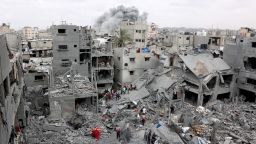 Palestinian rescuers check the site of Israeli bombardment on a residential building in Gaza City's Shujaiyya neighbourhood while smokes from another strike billows in the background, on April 9, 2025. The Israeli military said it targeted a senior Hamas militant on April 9, in a strike that Gaza's civil defence agency said hit a residential building in Gaza City, killing at least 20 people. (Photo by Omar AL-QATTAA / AFP) (Photo by OMAR AL-QATTAA/AFP via Getty Images)          