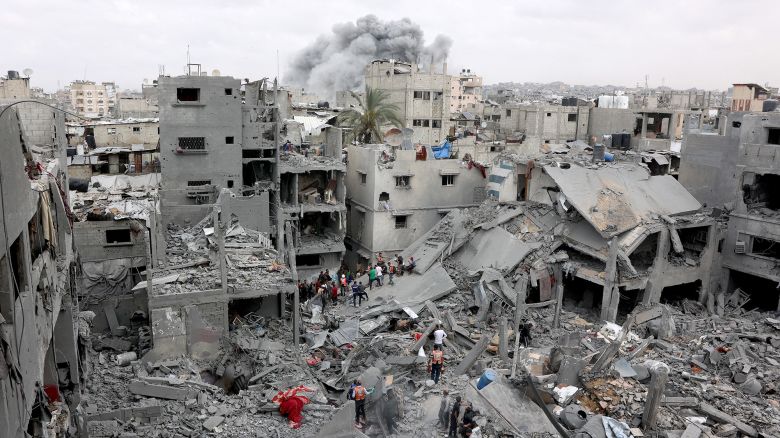 Palestinian rescuers check the site of Israeli bombardment on a residential building in Gaza City's Shujaiyya neighbourhood while smokes from another strike billows in the background, on April 9, 2025. The Israeli military said it targeted a senior Hamas militant on April 9, in a strike that Gaza's civil defence agency said hit a residential building in Gaza City, killing at least 20 people. (Photo by Omar AL-QATTAA / AFP) (Photo by OMAR AL-QATTAA/AFP via Getty Images)          