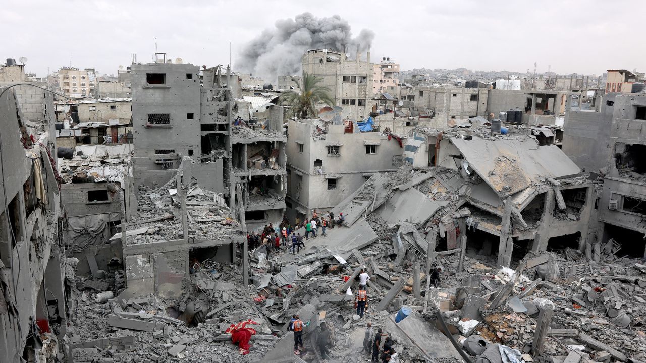 Palestinian rescuers check the site of Israeli bombardment on a residential building in Gaza City's Shujaiyya neighbourhood while smokes from another strike billows in the background, on April 9, 2025. The Israeli military said it targeted a senior Hamas militant on April 9, in a strike that Gaza's civil defence agency said hit a residential building in Gaza City, killing at least 20 people. (Photo by Omar AL-QATTAA / AFP) (Photo by OMAR AL-QATTAA/AFP via Getty Images)          