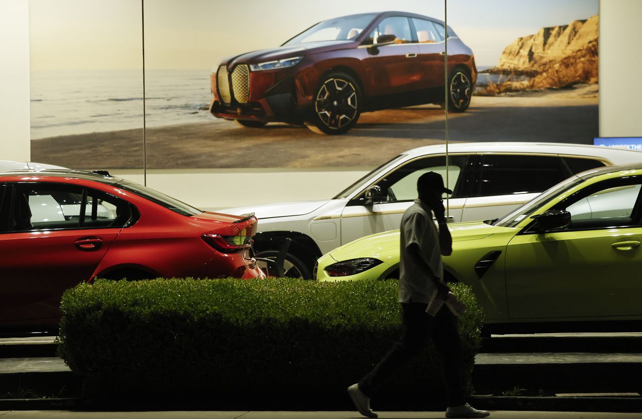 A person walks past cars displayed for sale at a dealership on April 7 in Glendale, California.