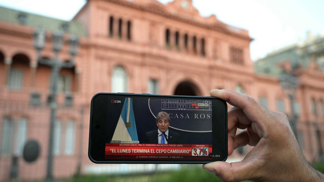 A journalist shows a cell phone displaying the presser of Argentina's Economy Minister Luis Caputo banned for photojournalists outside the Casa Rosada in Buenos Aires on April 11, 2025. The International Monetary Fund on Tuesday announced it had reached a preliminary agreement with Argentina on a $20 billion four-year loan arrangement to  a "comprehensive economic program." (Photo by JUAN MABROMATA / AFP) (Photo by JUAN MABROMATA/AFP via Getty Images)          