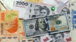 This photo illustration shows 20,000 Argentinian pesos, 2,000 Argentinian pesos, 1,000 Argentinian pesos, and 100 US dollar banknotes in Buenos Aires on April 11, 2025. The International Monetary Fund on Tuesday announced it had reached a preliminary agreement with Argentina on a $20 billion four-year loan arrangement to support a "comprehensive economic program."