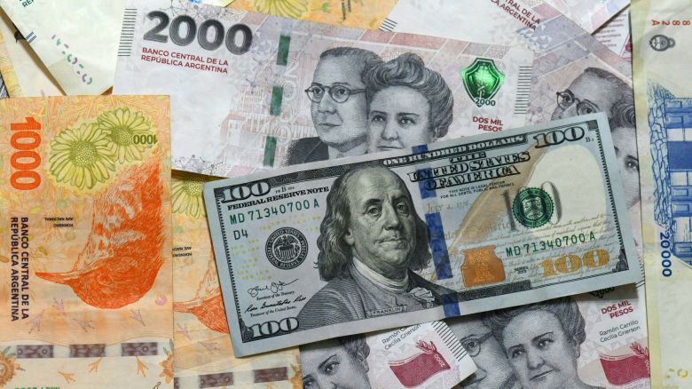 This photo illustration shows 20,000 Argentinian pesos, 2,000 Argentinian pesos, 1,000 Argentinian pesos, and 100 US dollar banknotes in Buenos Aires on April 11, 2025. The International Monetary Fund on Tuesday announced it had reached a preliminary agreement with Argentina on a $20 billion four-year loan arrangement to support a "comprehensive economic program."