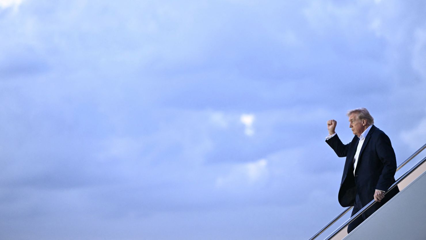 US President Donald Trump raises a fist as he steps off Air Force One in West Palm Beach, Florida, on April 11.