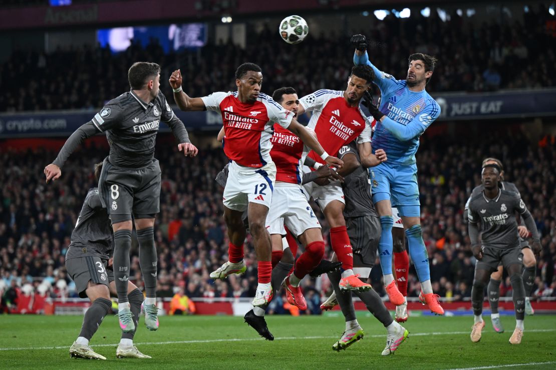Jurrien Timber, Mikel Merino y William Saliba del Arsenal disputan un centro con Thibaut Courtois del Real Madrid.