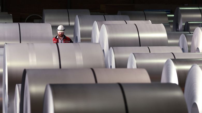 Un trabajador camina entre bobinas de acero terminado en una planta de Duisburgo, Alemania.